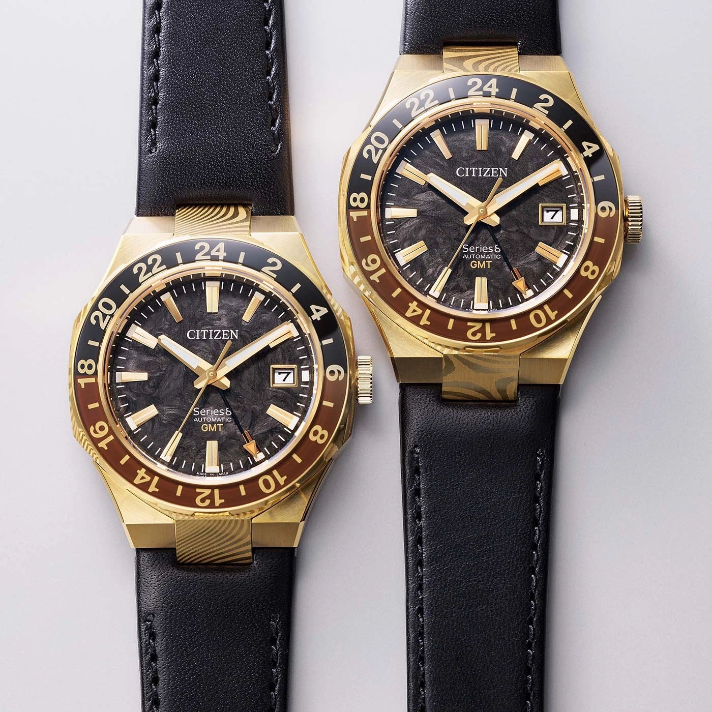 Twee gouden Citizen GMT-horloges met zwarte leren bandjes