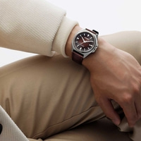 Man draagt Citizen horloge met bruine leren band en bruine wijzerplaat.