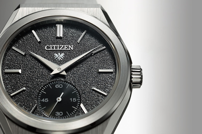 Close-up van een Citizen horloge met een zwarte wijzerplaat en zilveren wijzers.