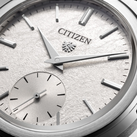 Close-up van een Citizen-horloge met een getextureerde zilveren wijzerplaat en wijzers.
