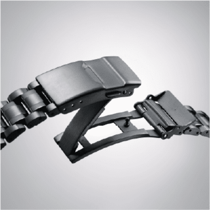 Close-up van een zwarte horlogebandsluiting, open en klaar om te sluiten.