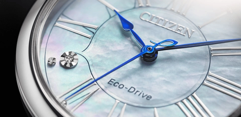 Close-up van een Citizen Eco-Drive horloge met blauwe wijzers en Romeinse cijfers.