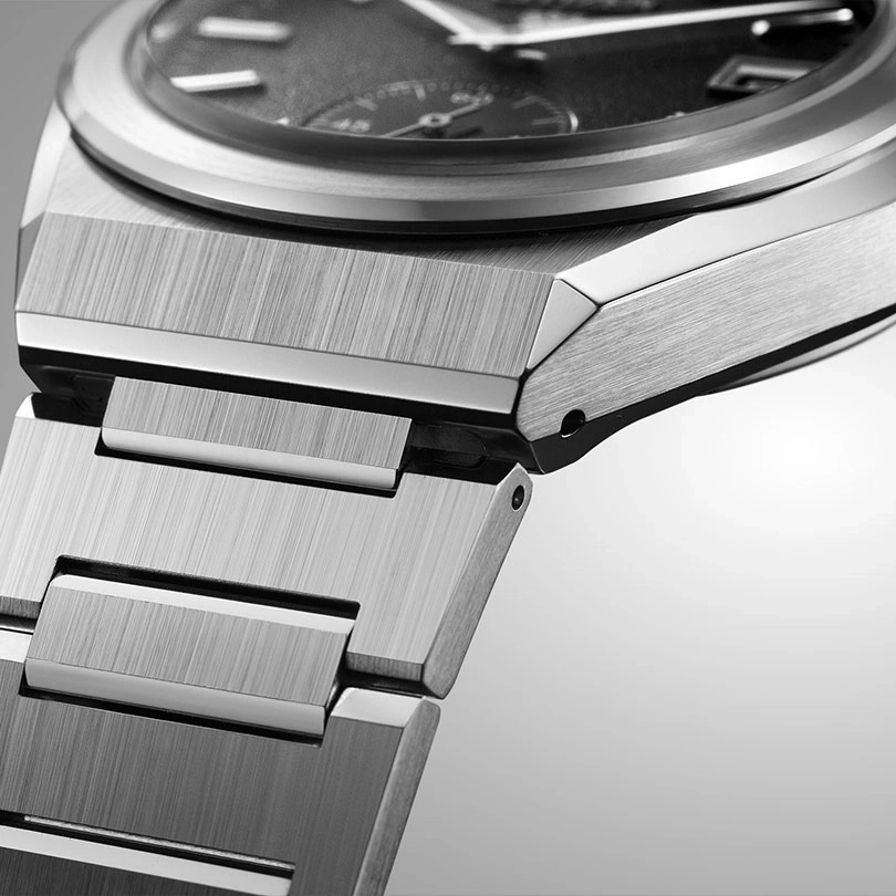 Close-up van een zilveren horloge met een metalen band en wijzerplaat.