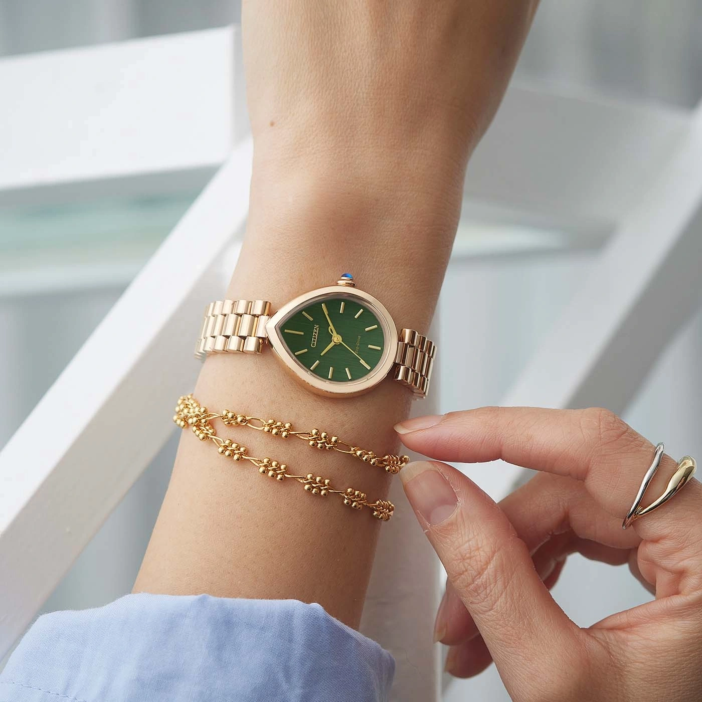 Een pols met een roségouden horloge en armband.