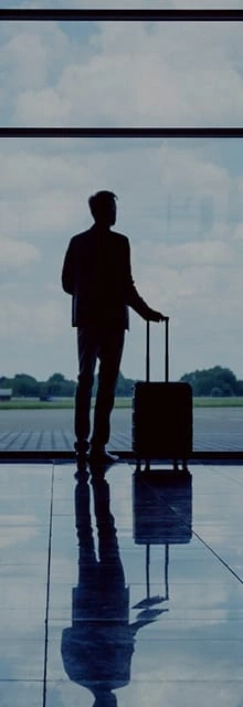 Man met koffer bij luchthavenraam, silhouet, wachten op vlucht