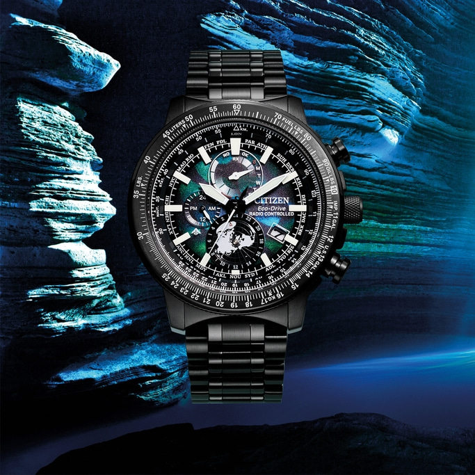 Zwart Citizen horloge met ingewikkelde wijzerplaat en band, tegen blauwe achtergrond.