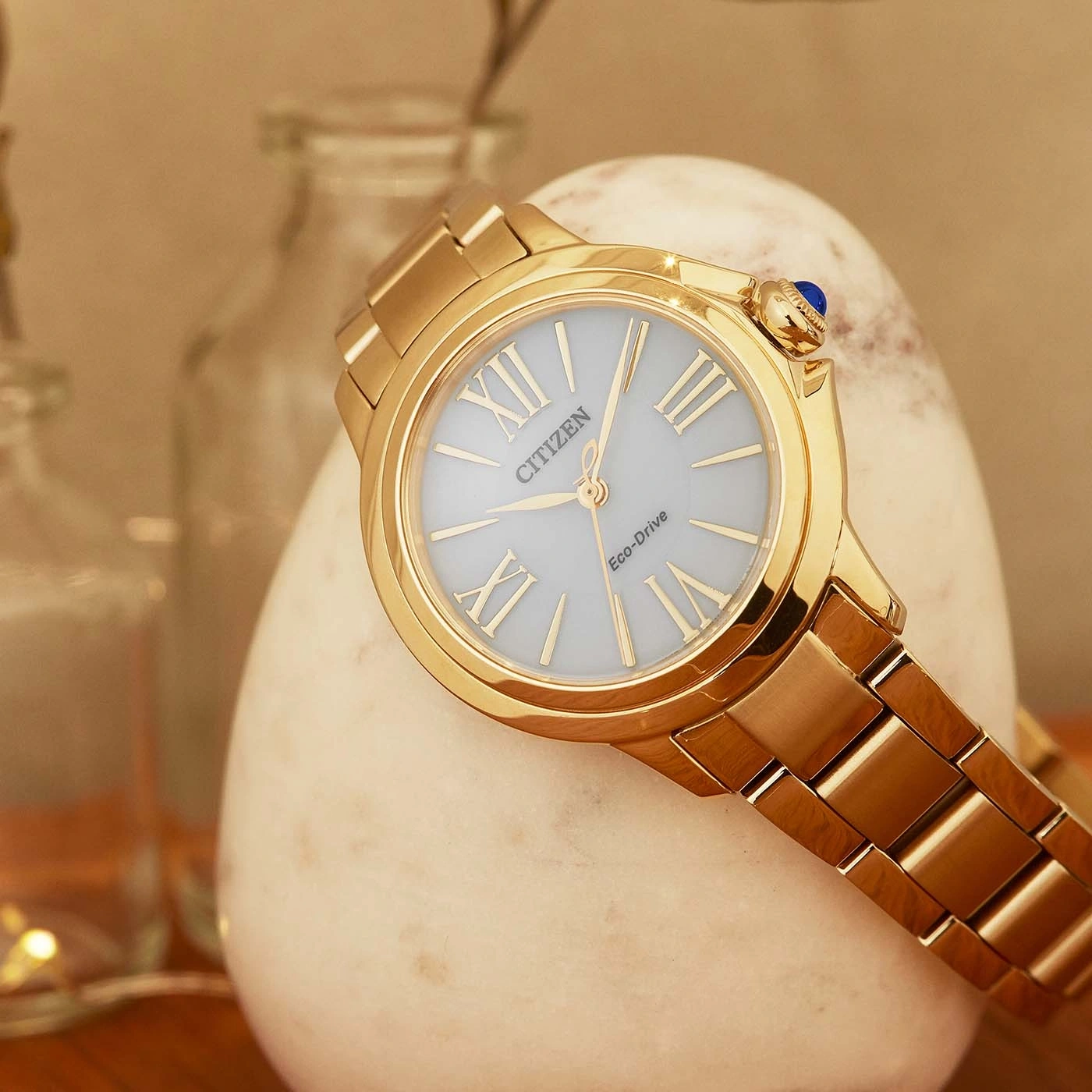 Gouden Citizen horloge op een witte steen, elegant en stijlvol design.