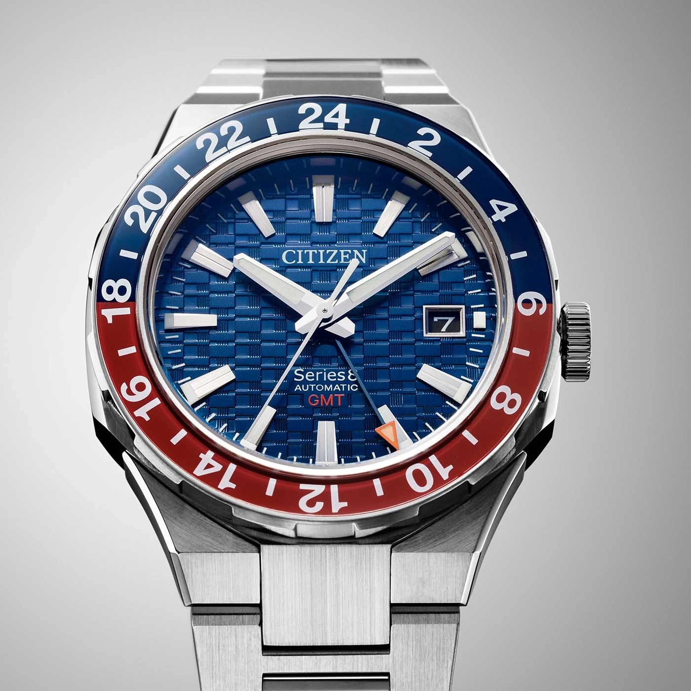 Citizen horloge met blauw en rode bezel, GMT-functie en datumweergave.