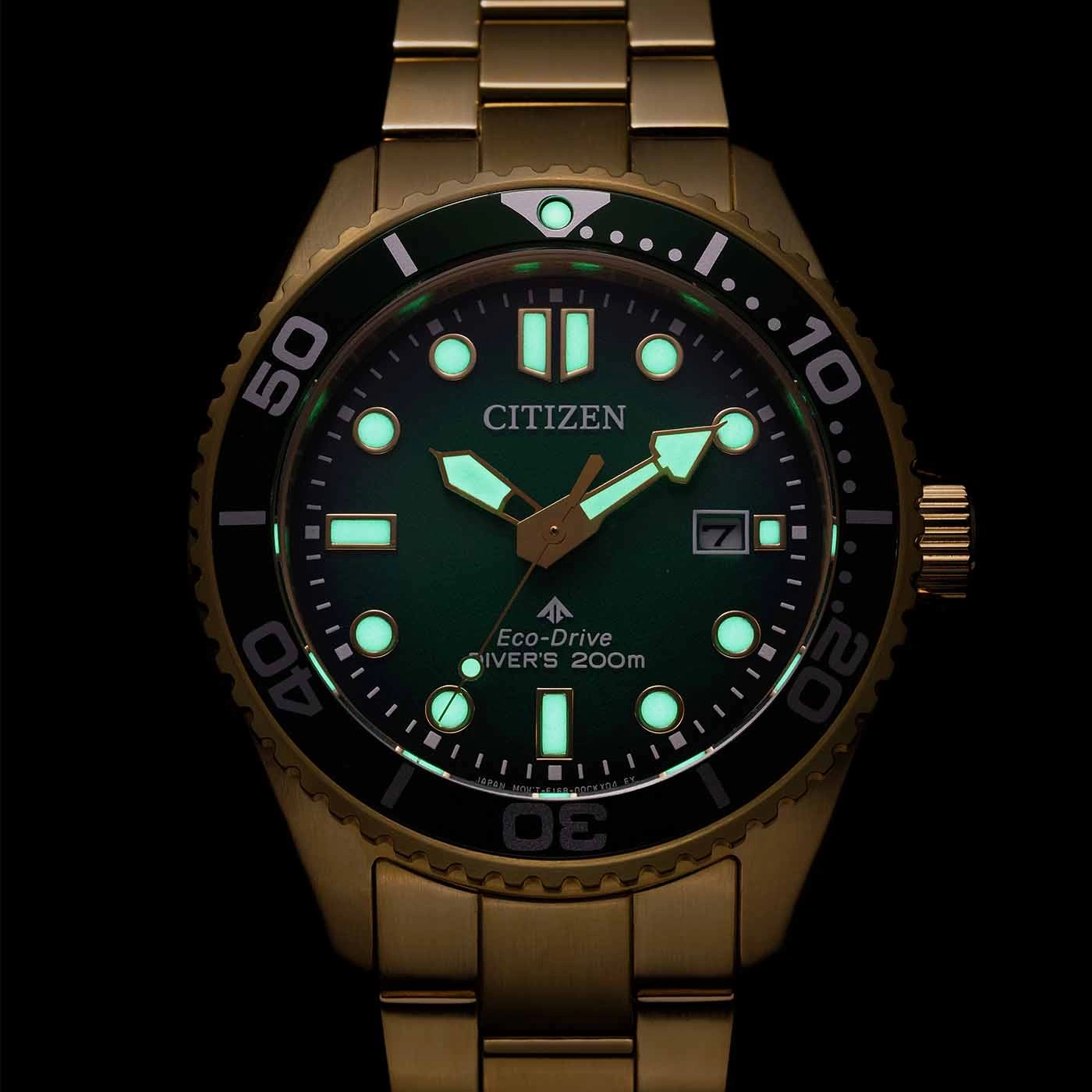 Citizen horloge met groene wijzerplaat en gouden band, gloeiend in het donker.