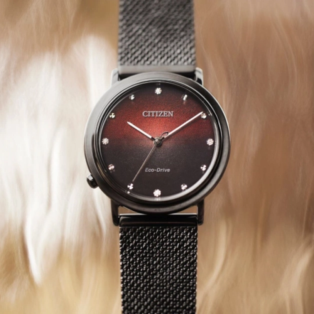 Citizen horloge met een zwarte band en een rode en zwarte wijzerplaat.