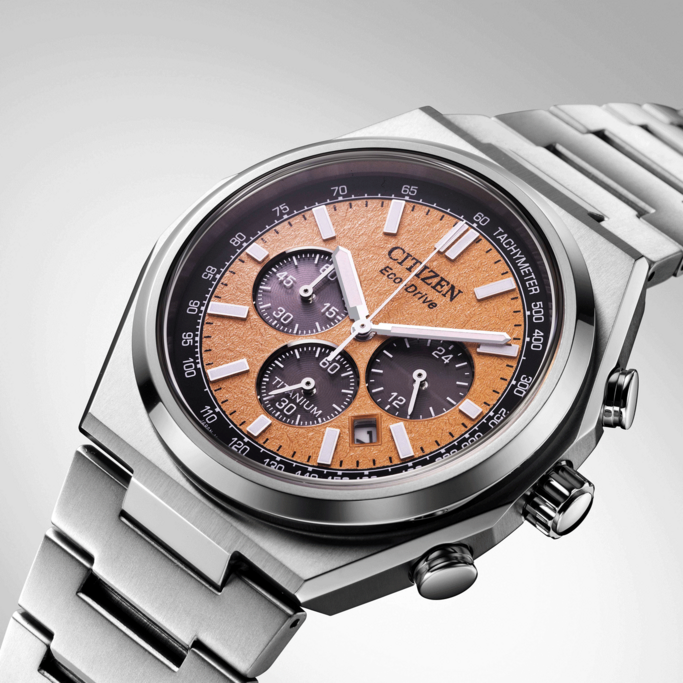 Citizen horloge met oranje wijzerplaat, titanium, chronograaf, Eco-Drive en tachymeter.