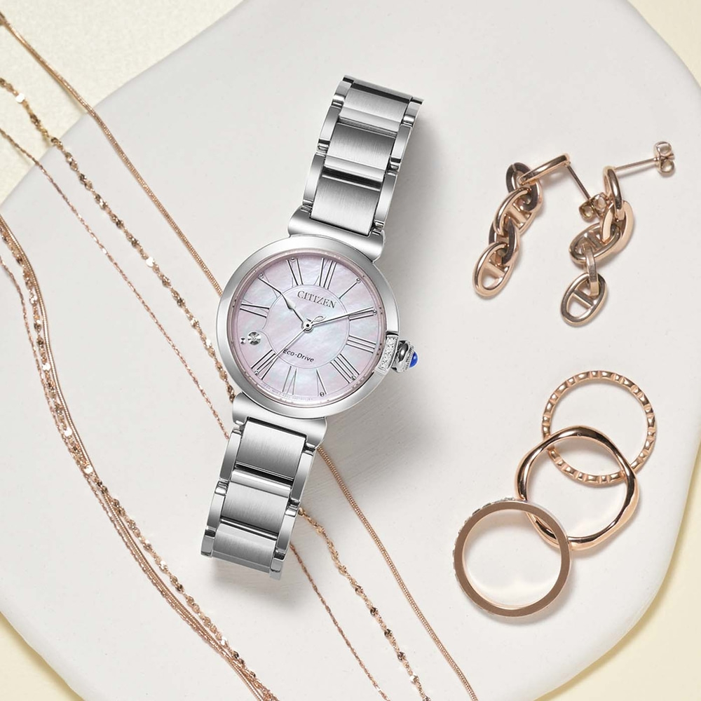 Een collectie elegante sieraden, waaronder een Citizen horloge, oorbellen en ringen.