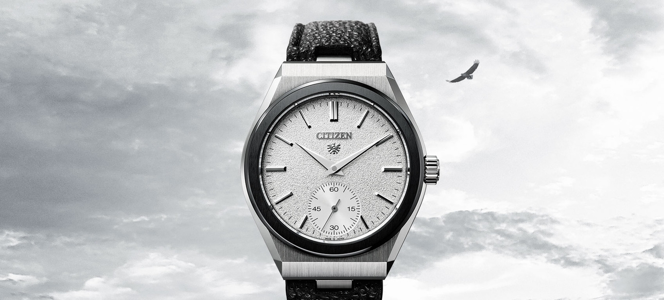 Citizen horloge met een getextureerde wijzerplaat en een zwarte leren band, met een adelaar in de lucht.