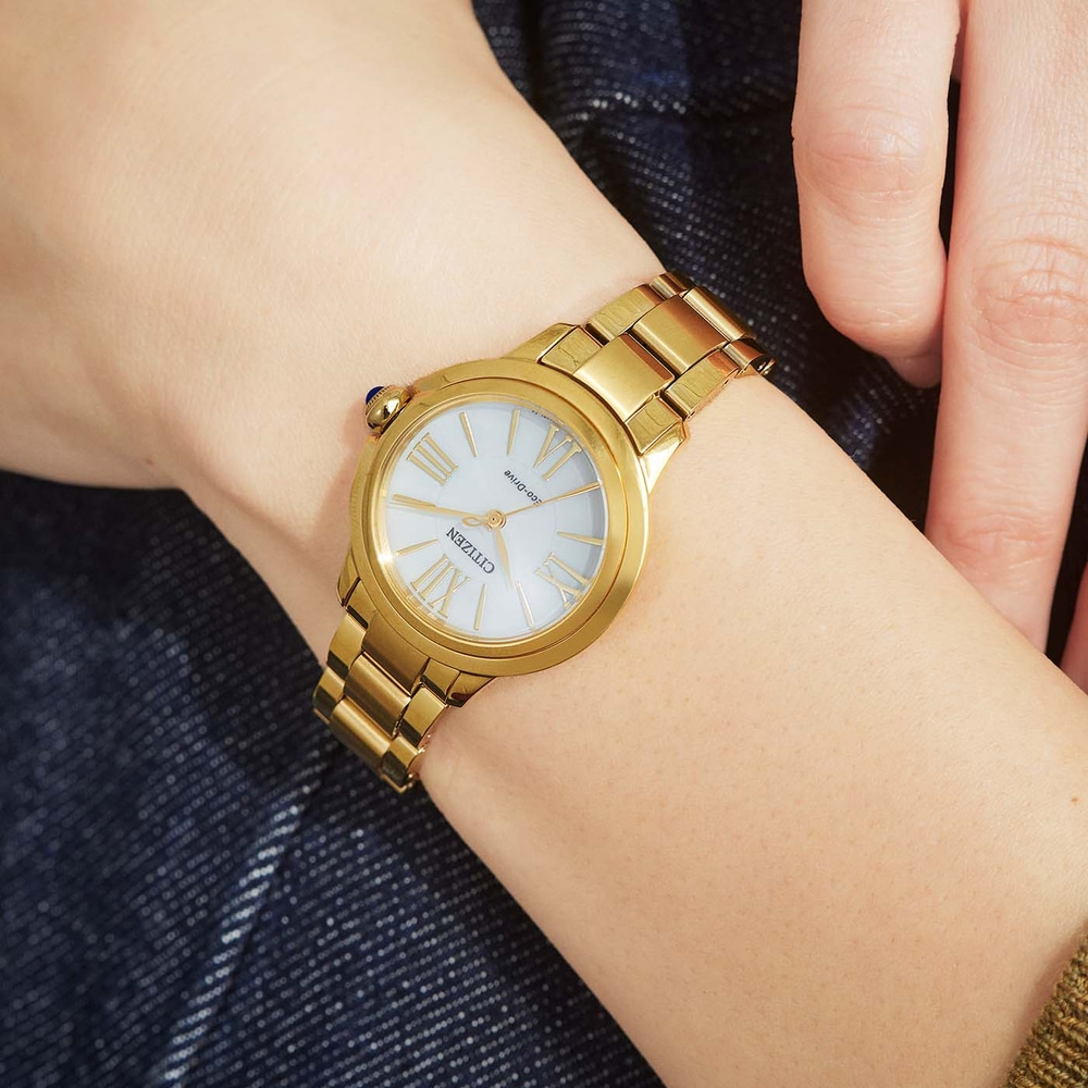 Gouden Citizen horloge om de pols, witte wijzerplaat, Romeinse cijfers, gouden armband, close-up