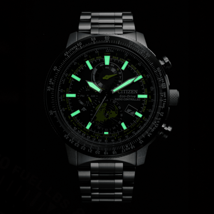 Citizen Eco-Drive horloge met oplichtende wijzers en markeringen, zwarte achtergrond, tijdweergave.