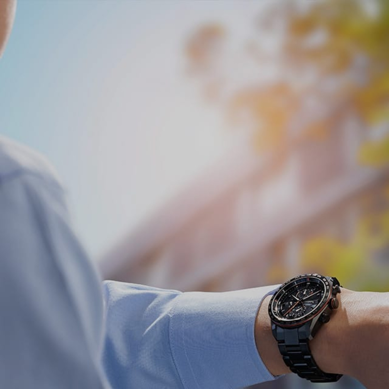 Man met zwart horloge, blauw overhemd, buiten, zonnige dag, polshorloge