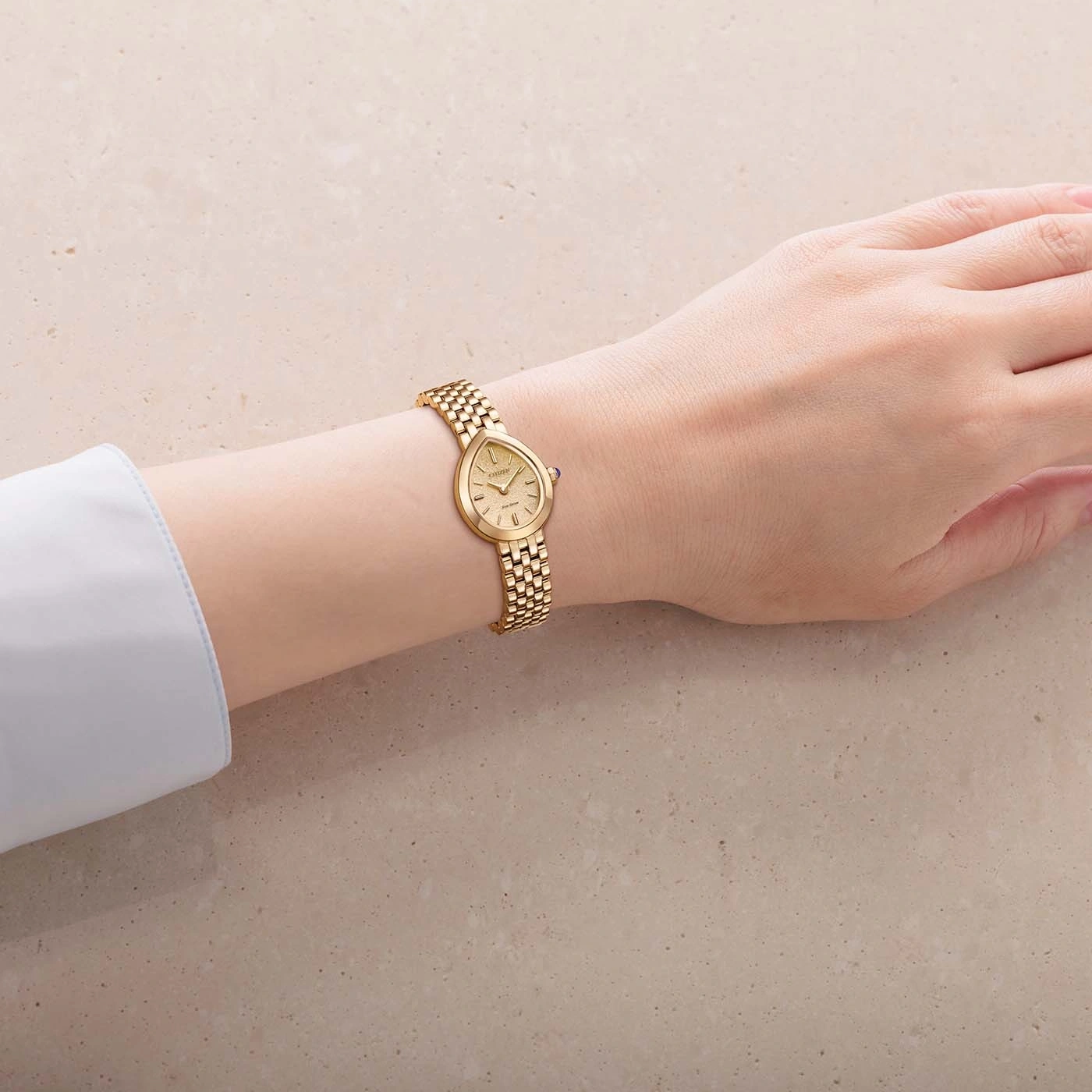 Een gouden horloge om de pols van een vrouw