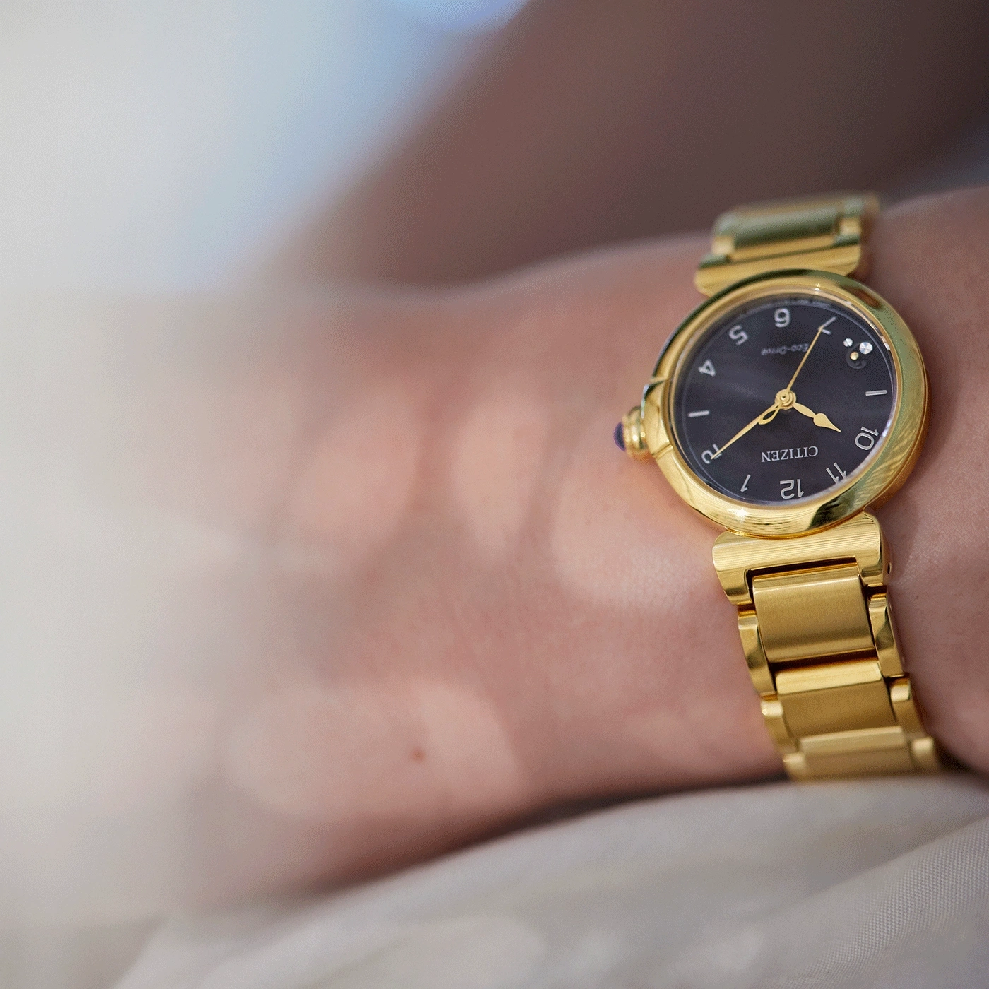 Close-up van een gouden Citizen horloge om een pols, elegant en stijlvol.