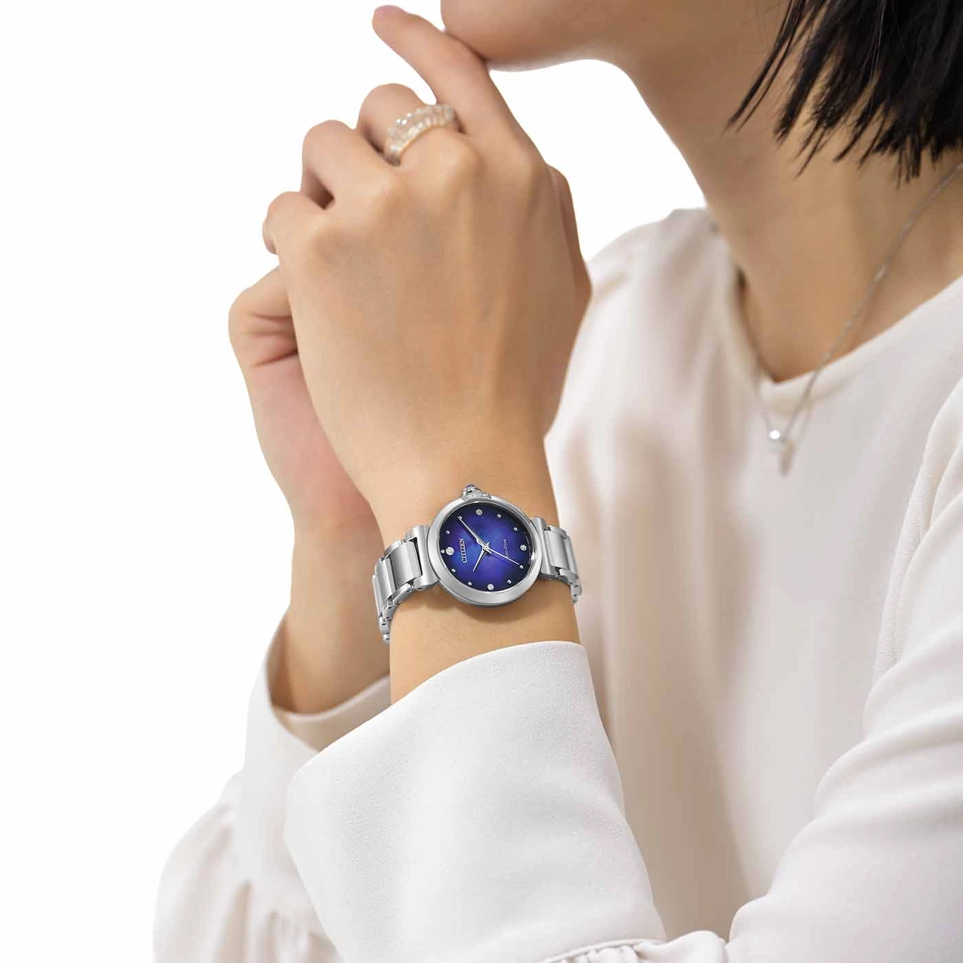 Vrouw met zilveren horloge met blauwe wijzerplaat en diamanten