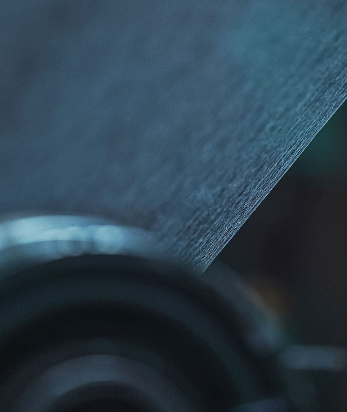 Close-up van een gestructureerd oppervlak met een vage achtergrond en donkere tinten.