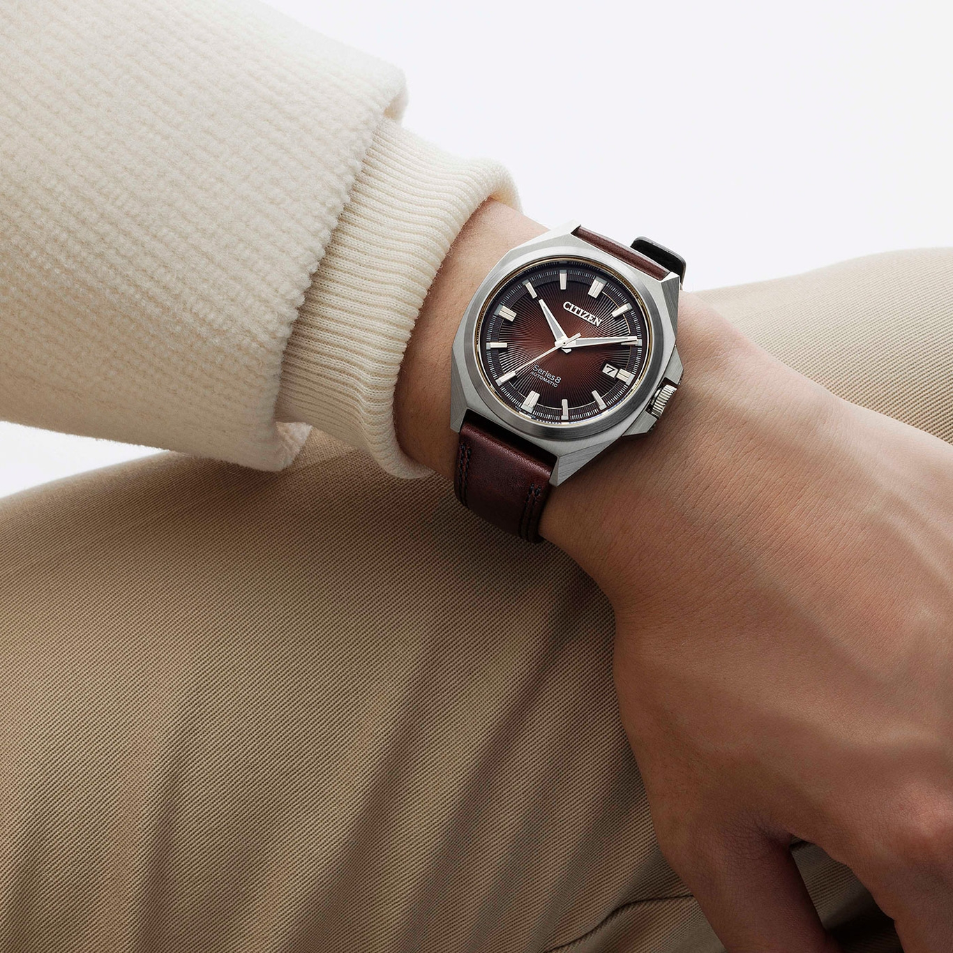 Citizen horloge om de pols, bruine leren band, bruine wijzerplaat, beige kleding