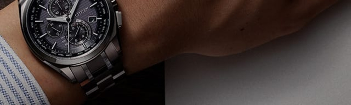 Close-up van een Citizen horloge om een pols, met de wijzerplaat en band.