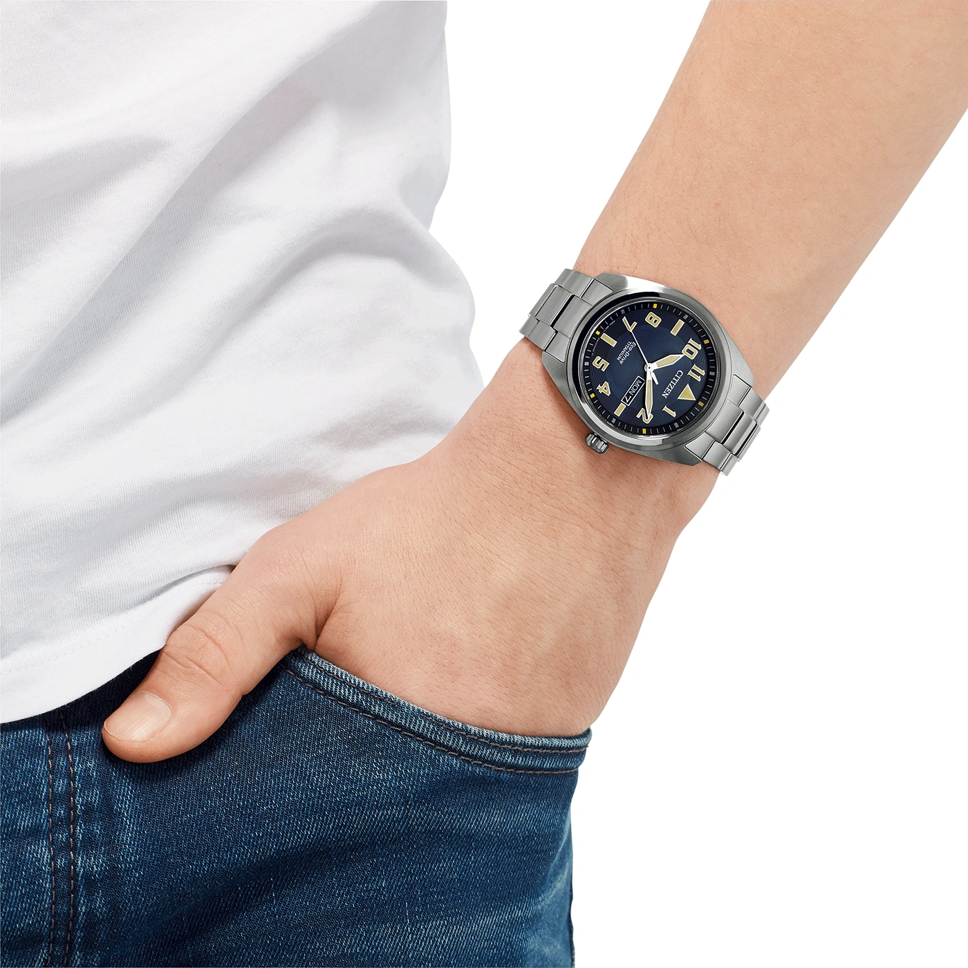 Man met Citizen horloge, blauwe wijzerplaat, roestvrijstalen armband, jeans en wit shirt.