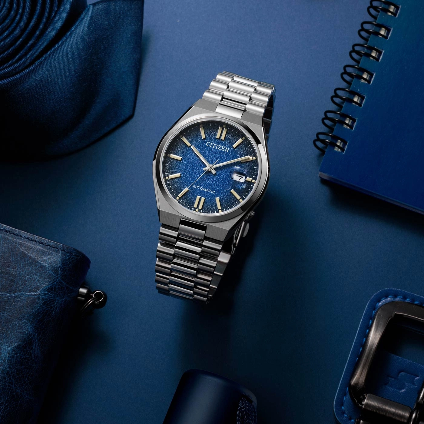 Citizen horloge op blauw oppervlak met accessoires, close-up, elegant