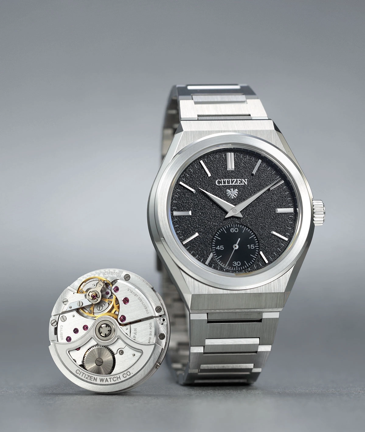 Citizen horloge met blootliggend mechanisme, zwarte wijzerplaat, zilveren armband en ingewikkelde details.