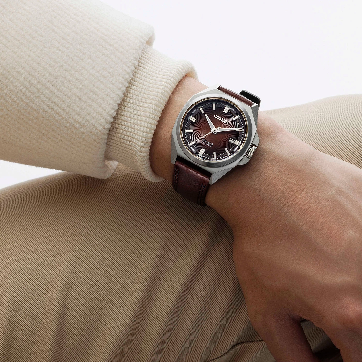 Citizen horloge om de pols, bruine leren band, bruine wijzerplaat, beige kleding