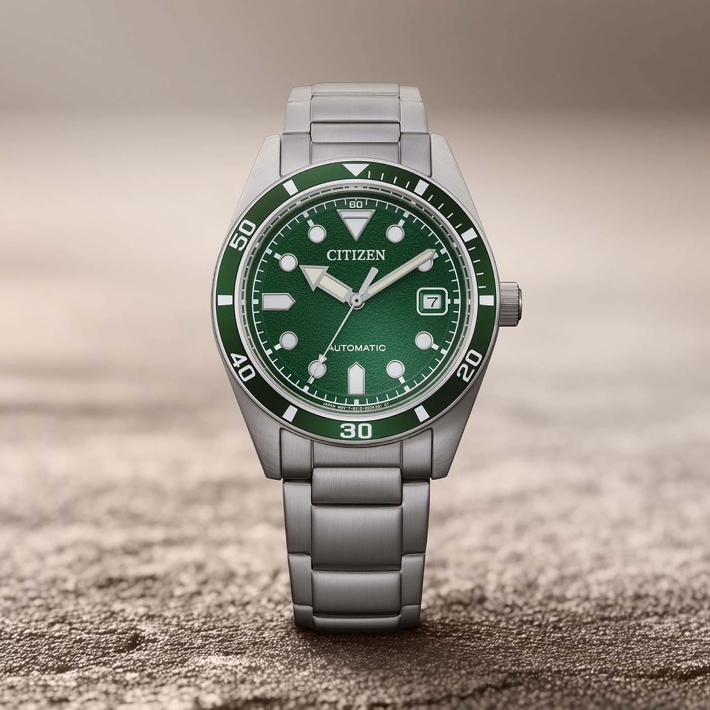 Een groen Citizen automatisch horloge met metalen band.