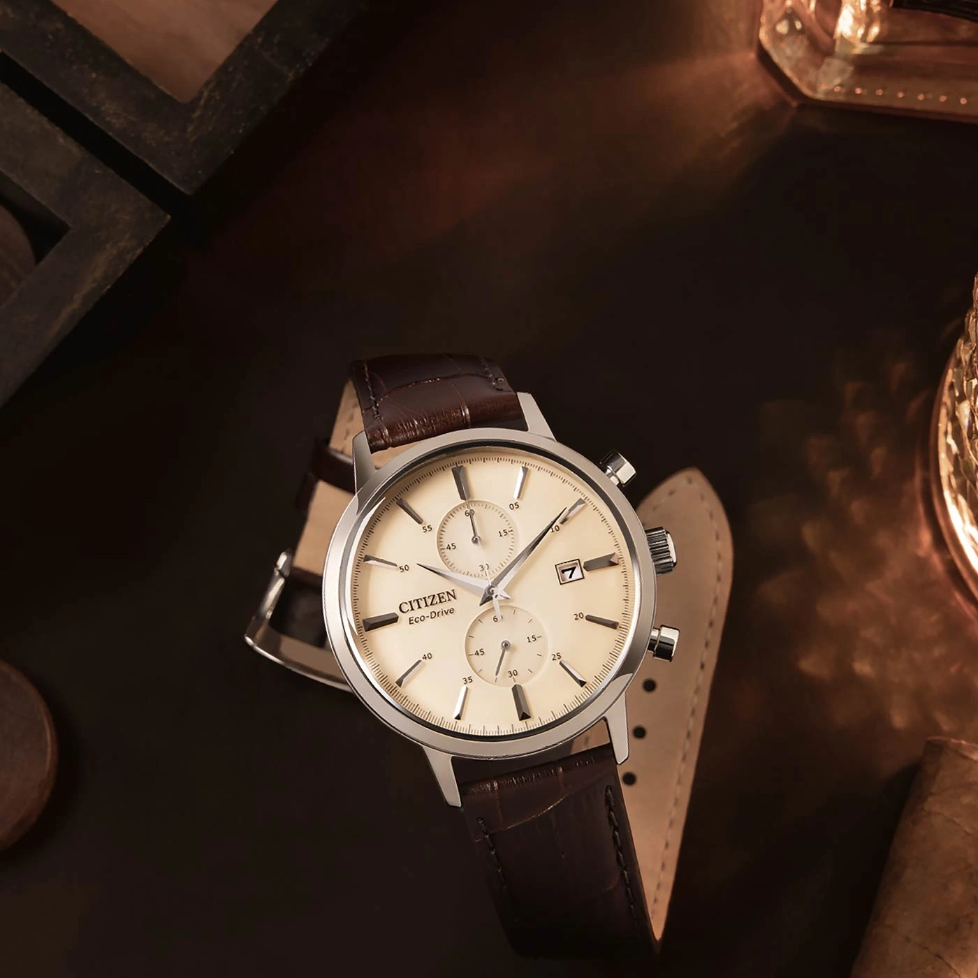 Citizen Eco-Drive horloge met bruine leren band op een donker oppervlak.