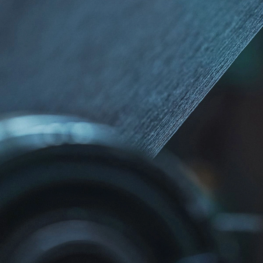 Close-up van een getextureerd, donkerblauw oppervlak met vage achtergrond en highlights.