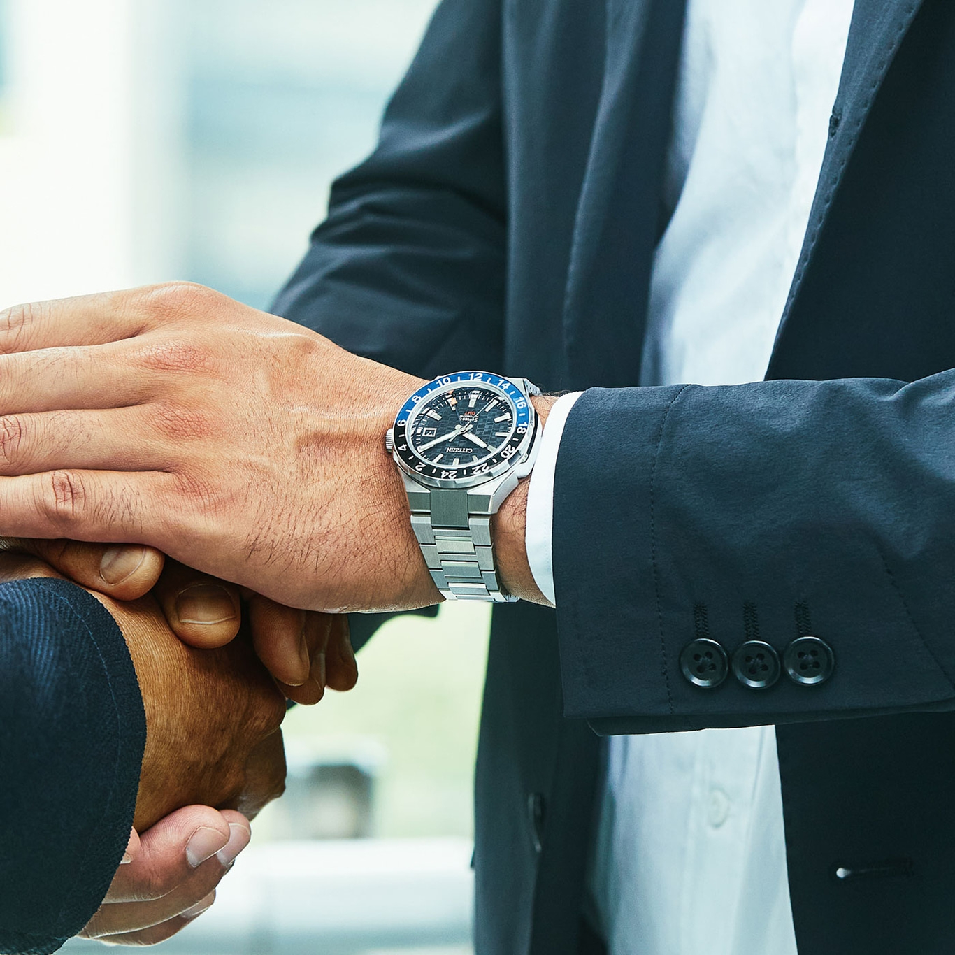 Man met horloge die handen schudt, zakelijke deal, close-up.