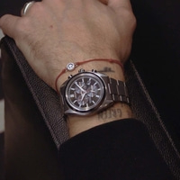 Mannelijke pols met horloge en smiley-armband.