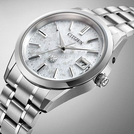 Citizen horloge met witte wijzerplaat en zilveren band, elegant design.