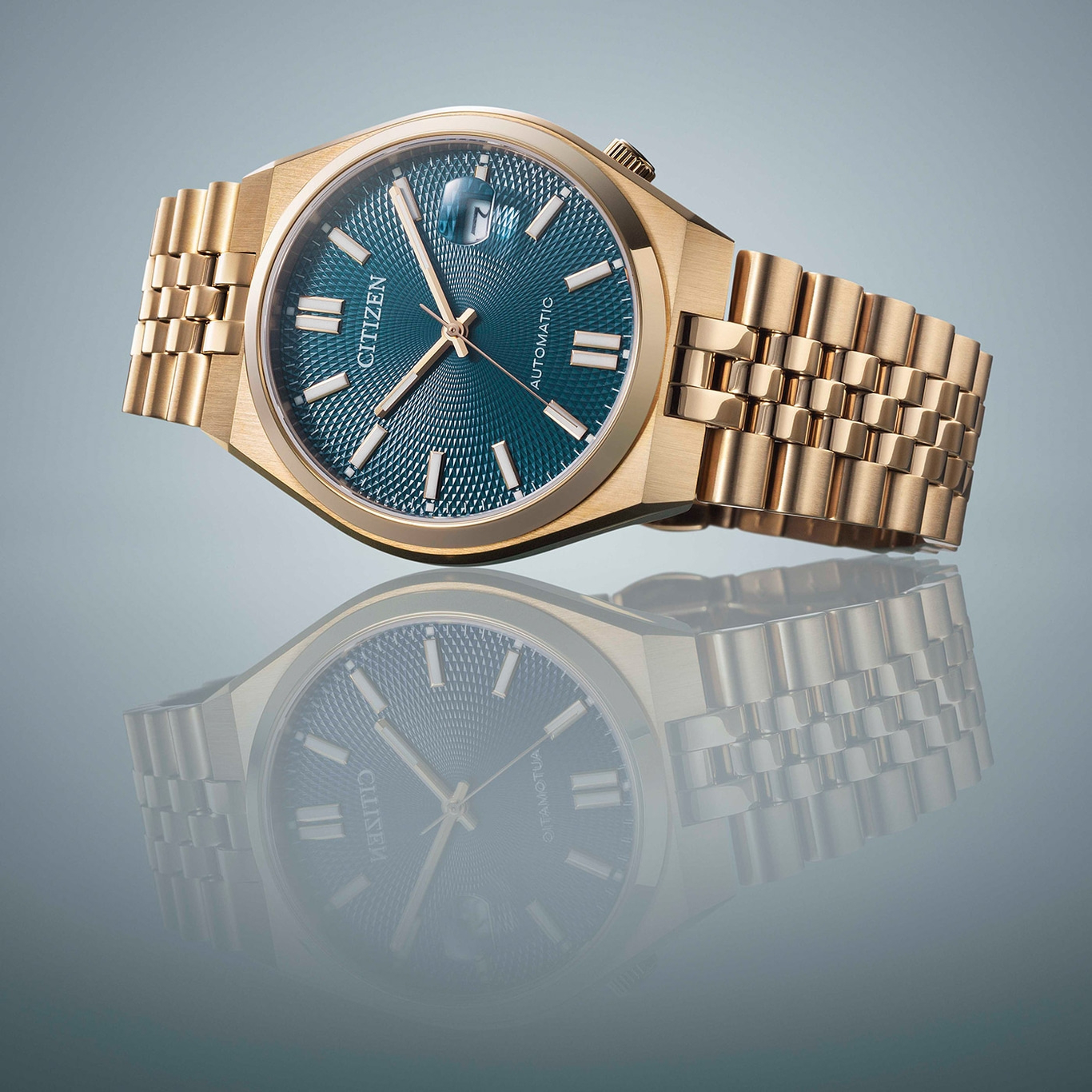 Gouden Citizen horloge met blauwe wijzerplaat en reflectie op een oppervlak.