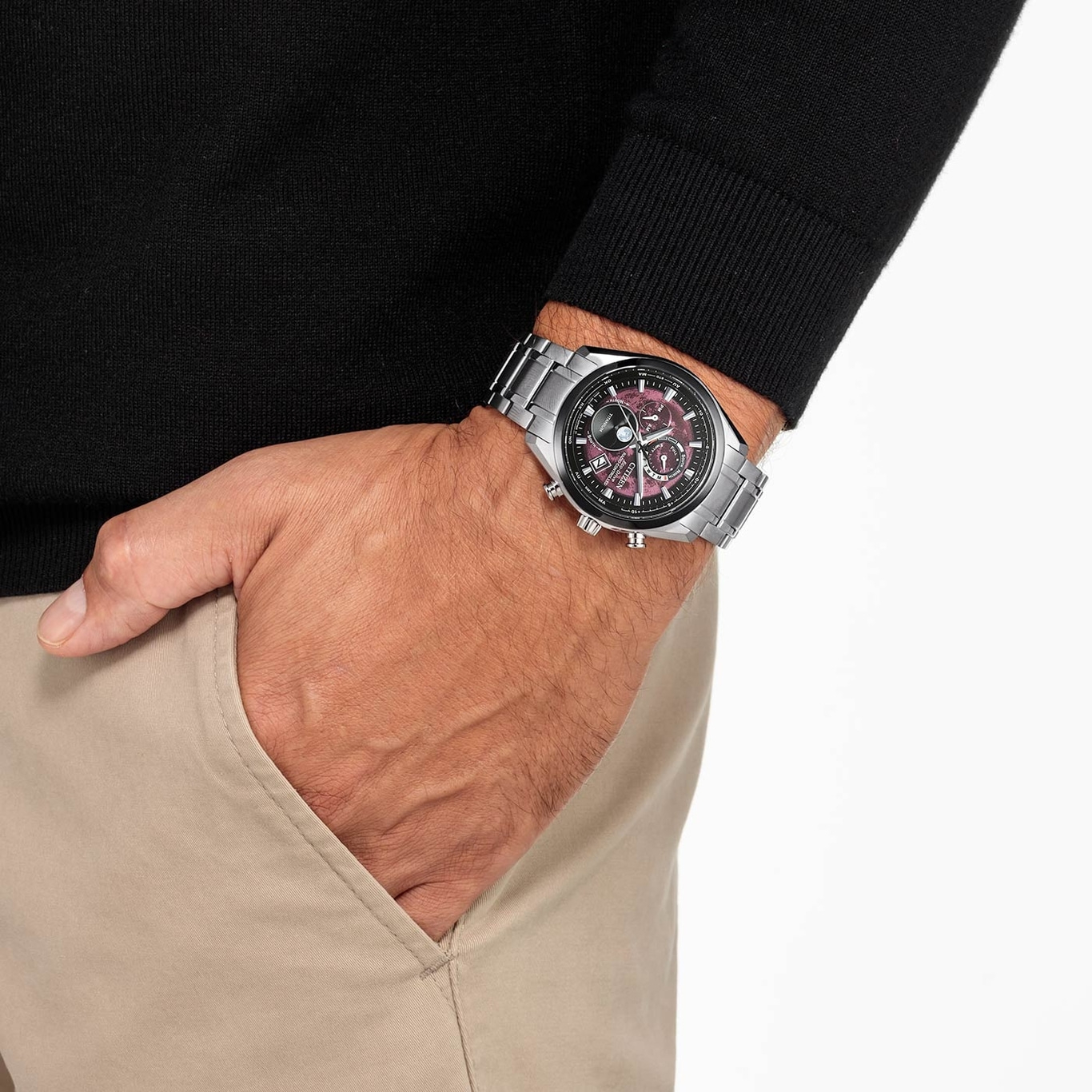 Man met horloge, hand in zak, zwarte trui, beige broek, close-up opname