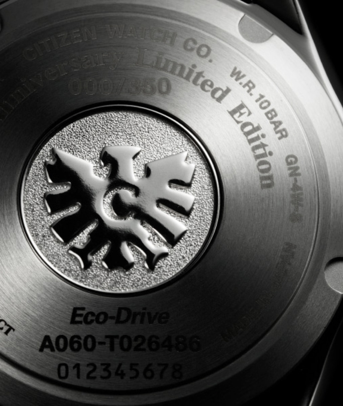 Close-up van de achterkant van een Citizen-horloge met tekst en logo, Eco-Drive.