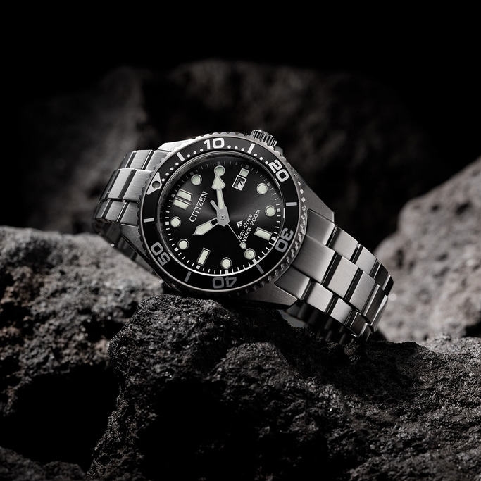 Een Citizen horloge op een rots. Zwarte wijzerplaat en zilveren armband.