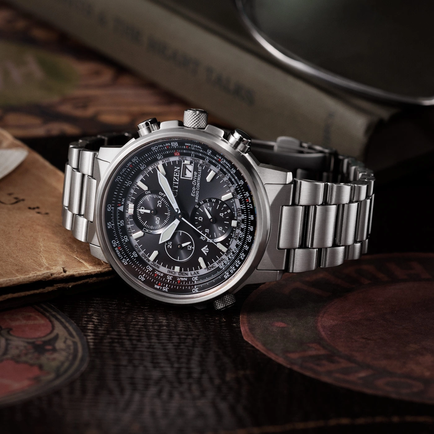 Citizen horloge met zwarte wijzerplaat en zilveren band op houten oppervlak.