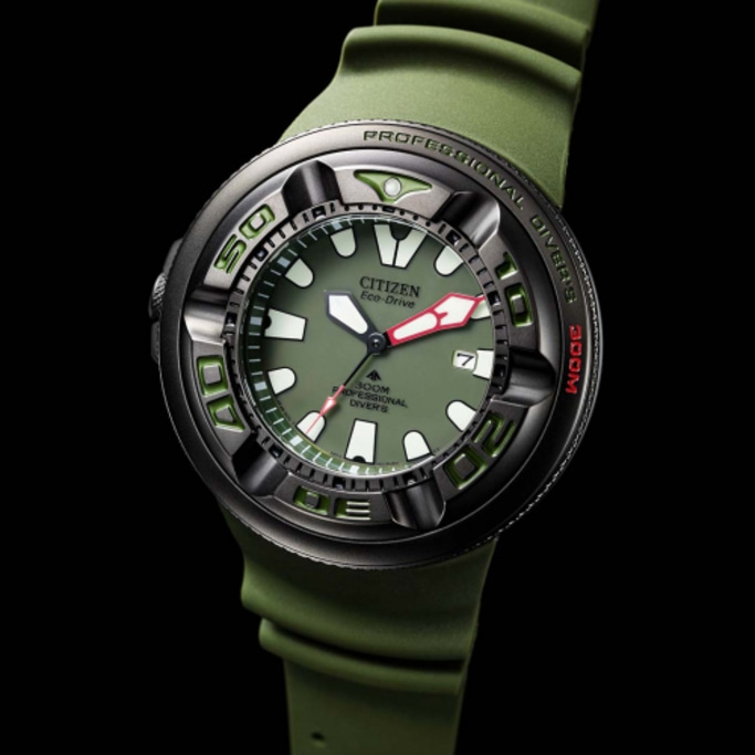 Citizen Eco-Drive horloge met groene band en wijzerplaat, zwarte achtergrond, close-up.