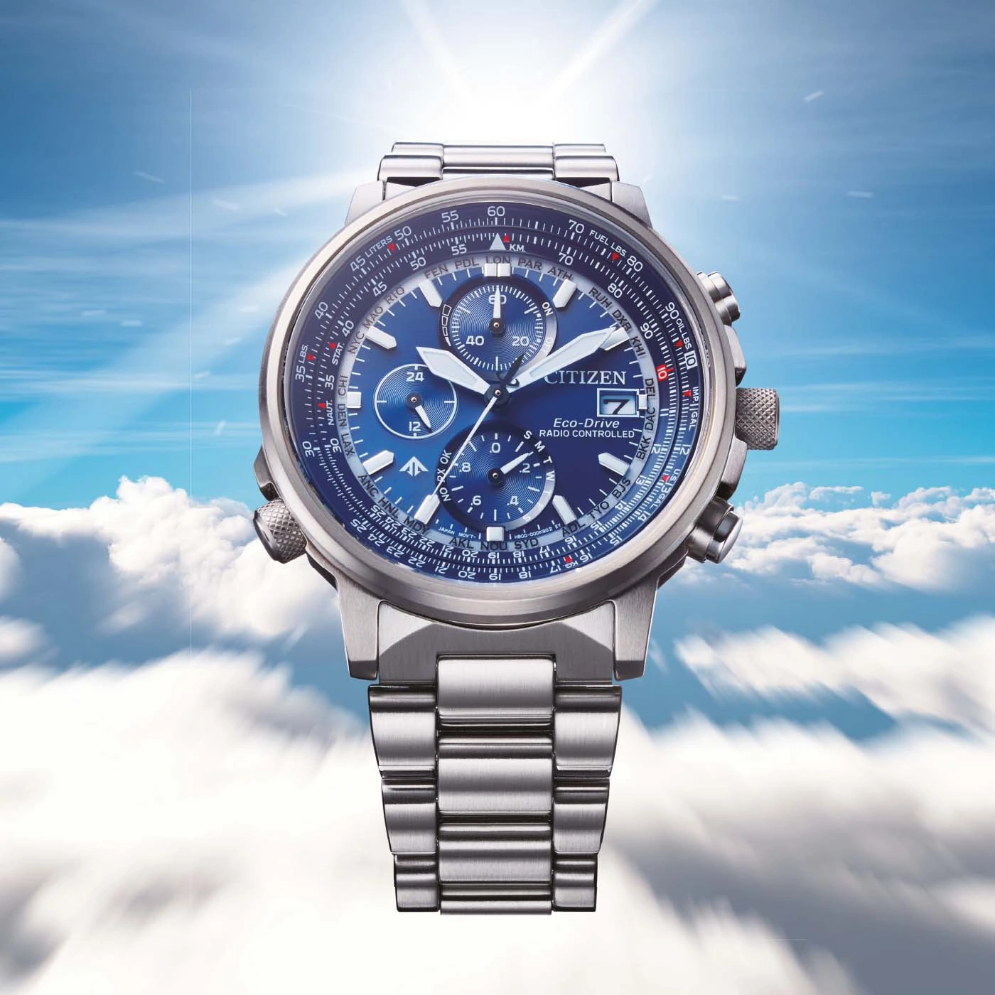 Citizen horloge met blauwe wijzerplaat, roestvrijstalen band en lucht achtergrond.