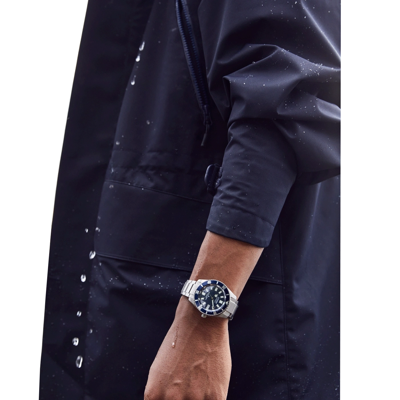 Man met horloge, donkerblauwe jas, waterdruppels, close-up, pols