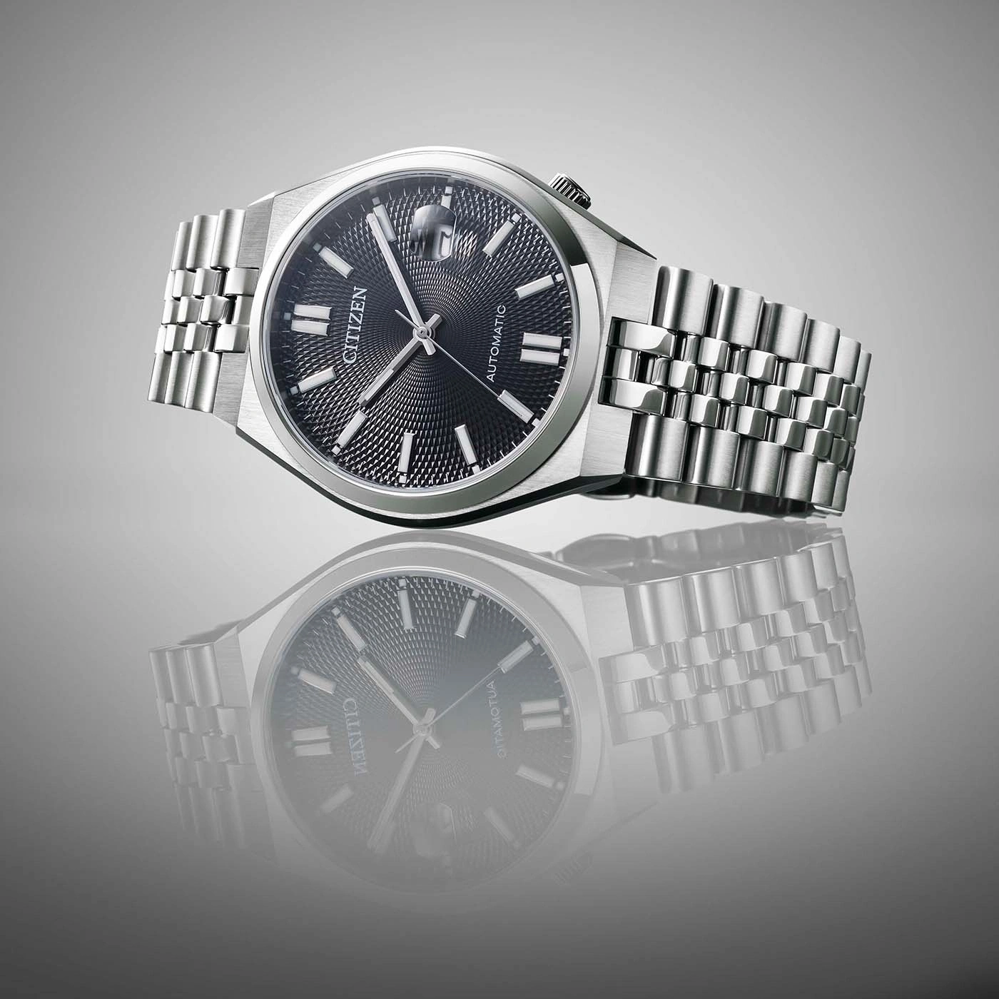 Citizen horloge met zwarte wijzerplaat en zilveren armband, reflectie.