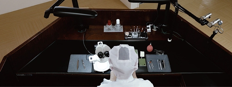 Werkbank van een horlogemaker met microscoop en gereedschap.