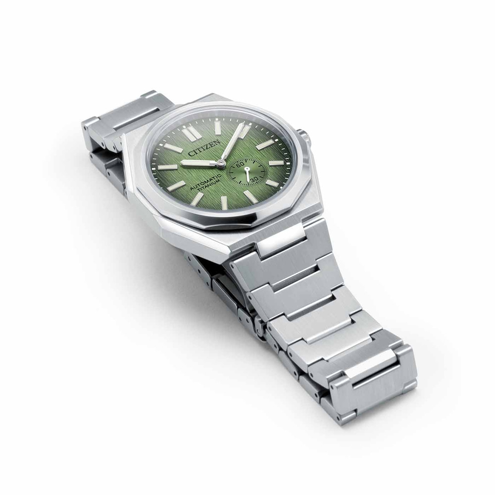 Citizen horloge met groene wijzerplaat en zilveren band op witte achtergrond
