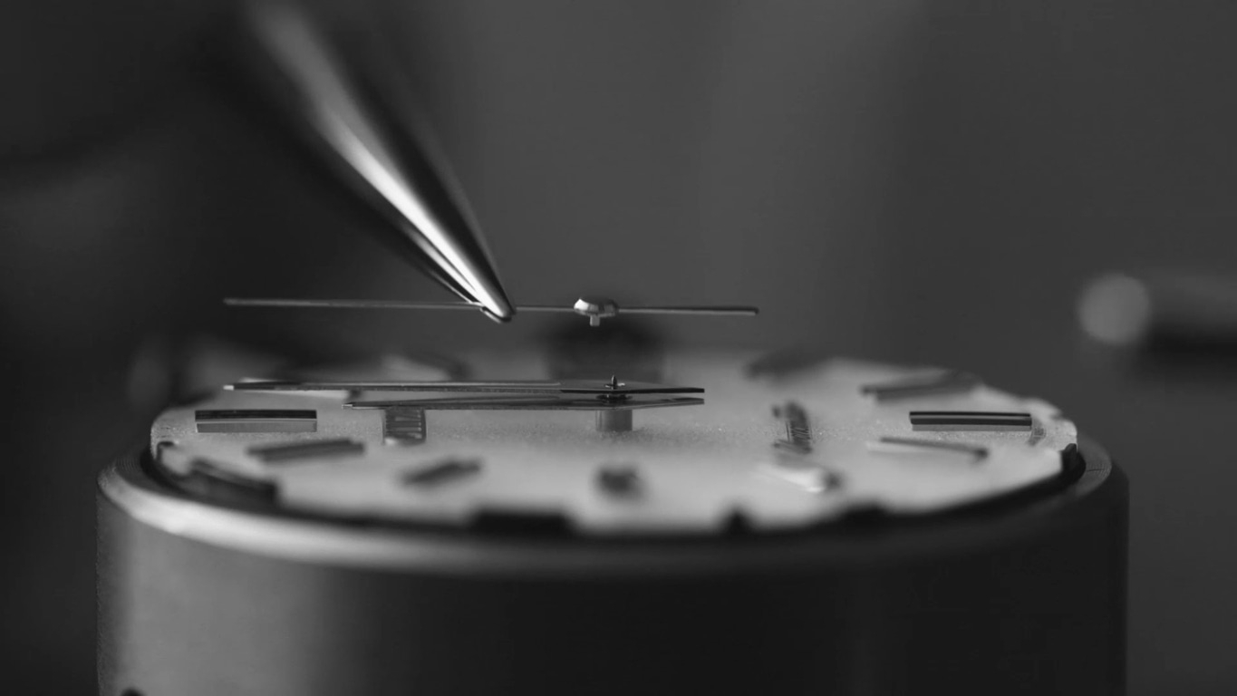 Close-up van het monteren van een horlogemechanisme met precisiegereedschap.