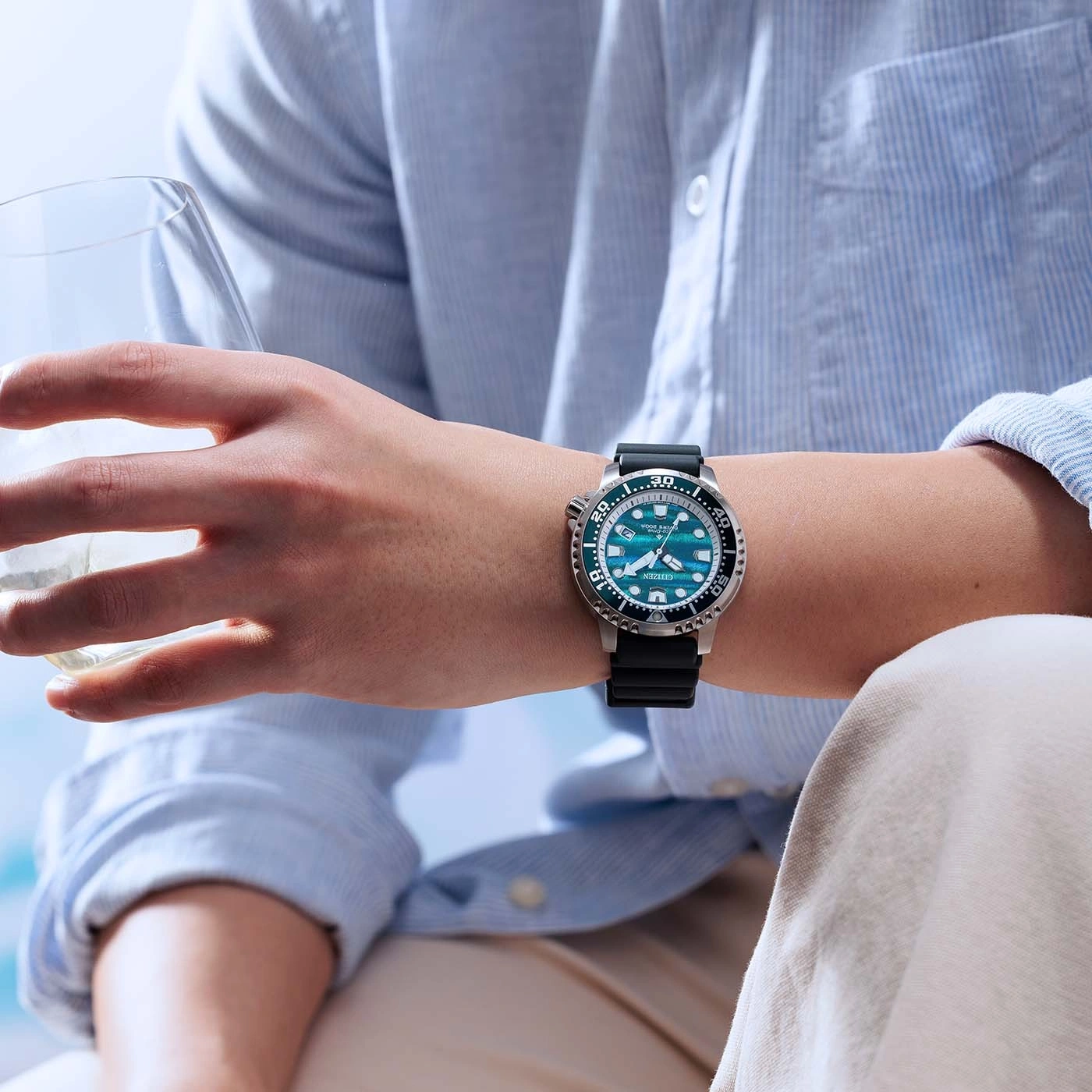 Een mannenpols draagt een blauw Citizen-horloge met een zwart bandje.