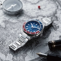 Citizen horloge op kaart met kompas en pen, reisthema, blauwe en rode bezel